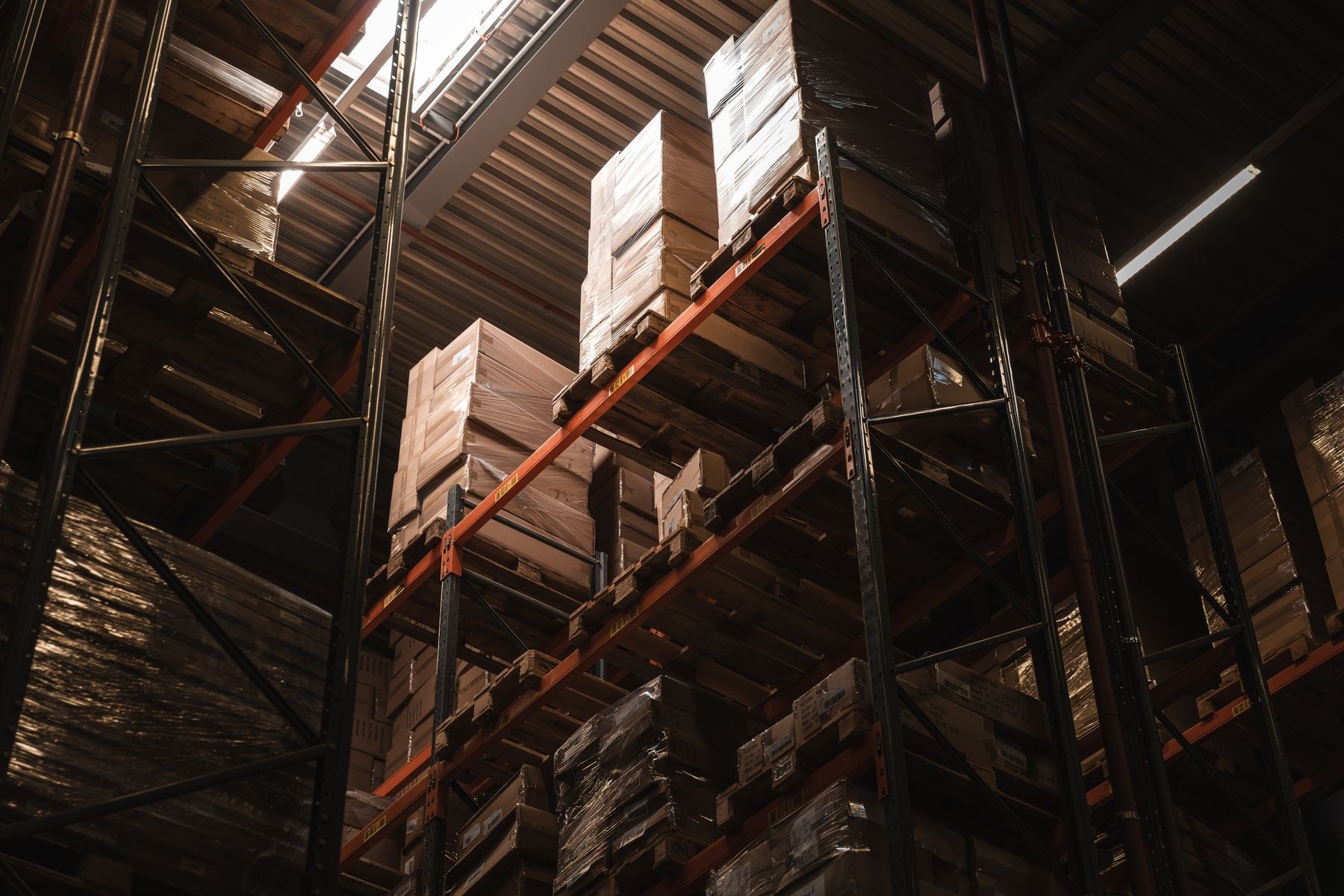Tall warehouse racks holding boxes and wrapped palletized goods
